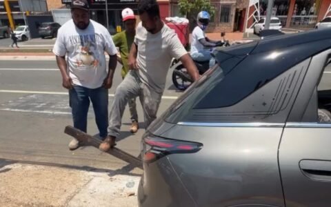 Cerca de 12 homens levantam carro preso em bueiro em Goiânia